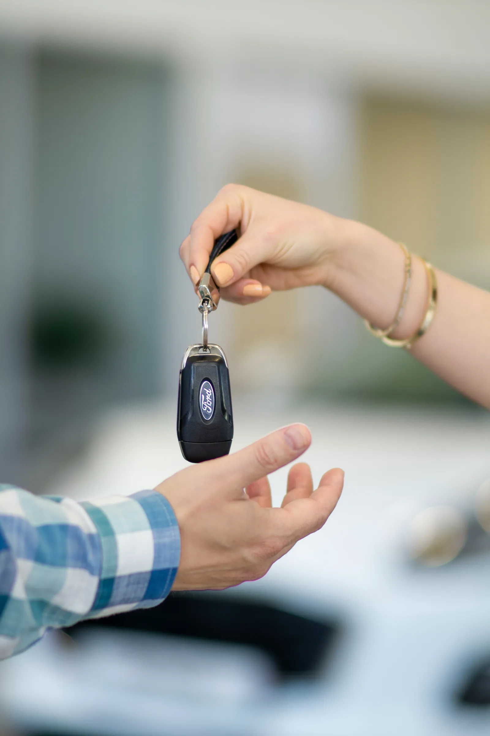 Una mano consegna le chiavi di un'auto a un'altra persona